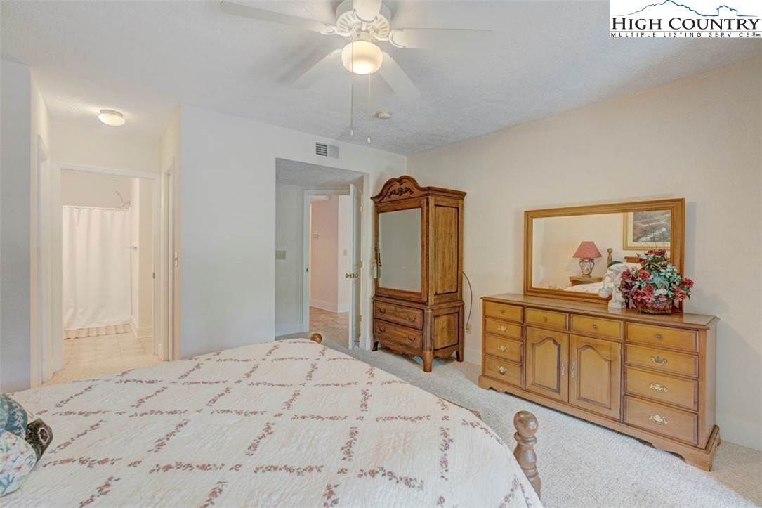 190 Still Lake Drive, Unit 321 Boone, NC 28607 - Photo 13 of 30 a bedroom with a bed and a chandelier