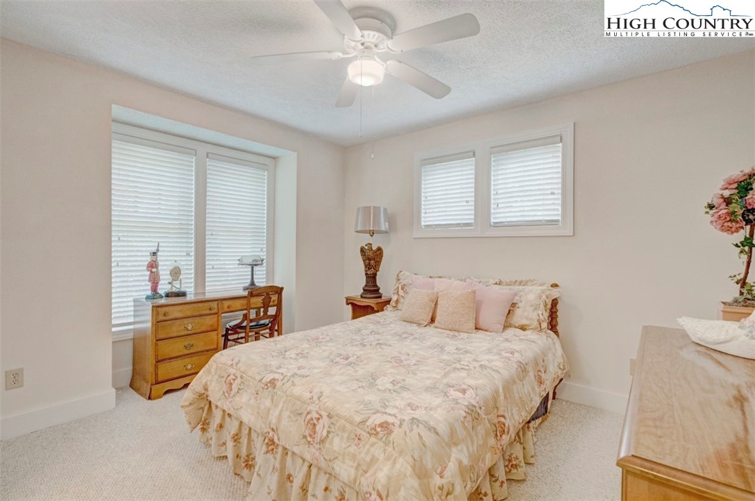 190 Still Lake Drive, Unit 321 Boone, NC 28607 - Photo 17 of 30 a bedroom with a bed and a chandelier