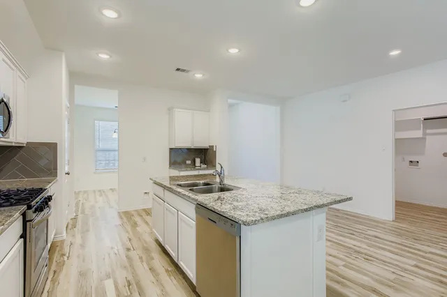 a kitchen with kitchen island a sink stove and refrigerator