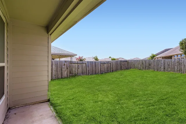 a view of a backyard with wooden fence