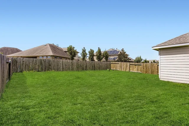 a view of a backyard with a garden and entertaining space