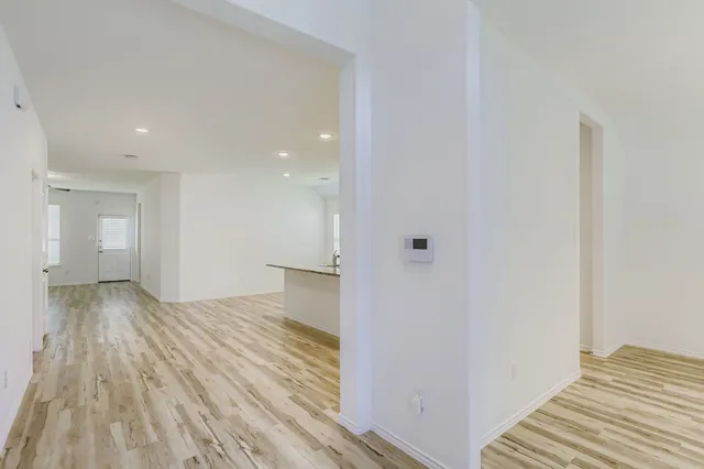 a view of a room with wooden floor and a bathroom