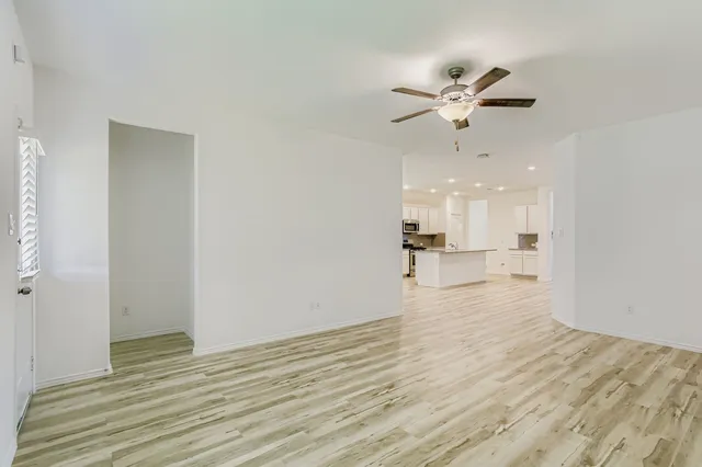 a view of a kitchen with wooden floor and a ceiling fan
