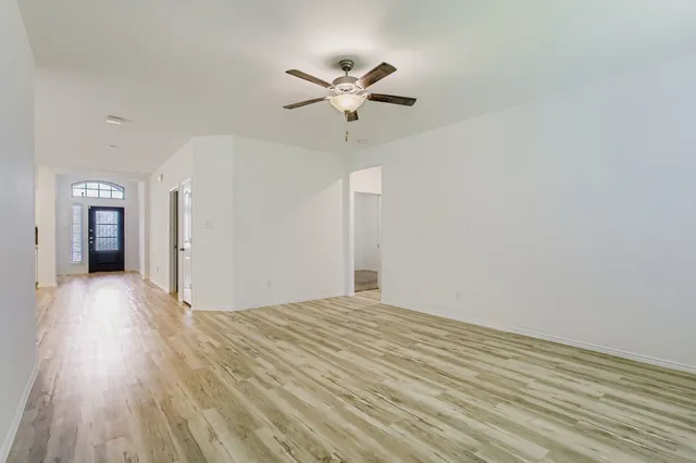 a view of a livingroom with a ceiling fan and wooden floor
