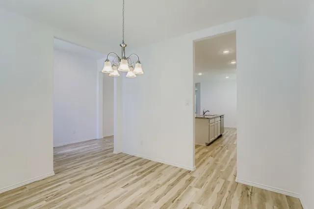 a view of a room with wooden floor and a ceiling fan