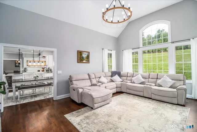 a living room with furniture chandelier and a large window