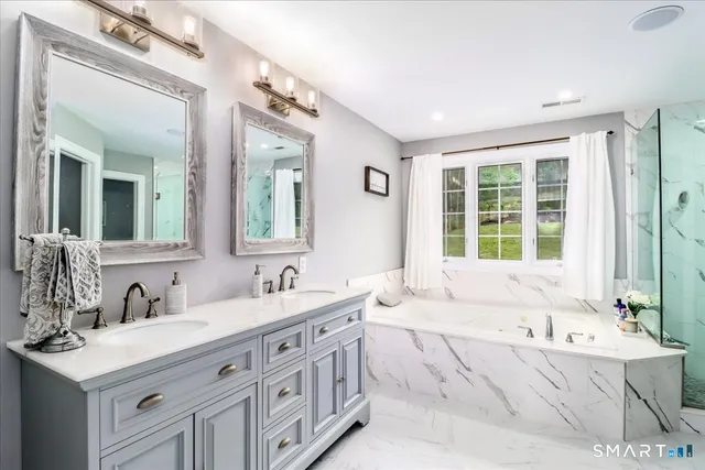 a bathroom with a tub sink and mirror
