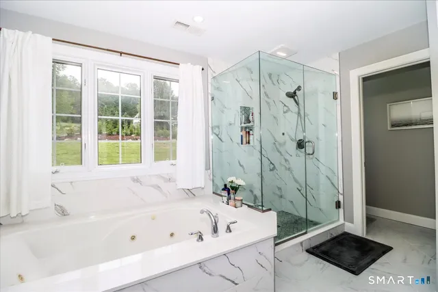 a bathroom with a tub a sink and a window