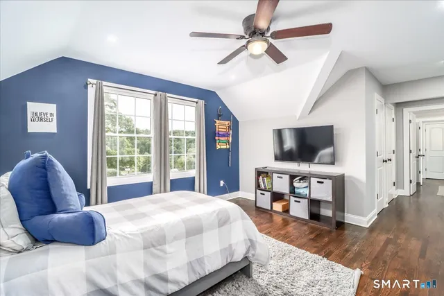 a bedroom with a bed a flat screen tv and a chandelier
