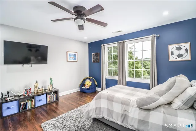 a bedroom with a bed a window and a flat screen tv