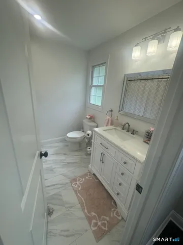 a bathroom with a sink toilet and mirror