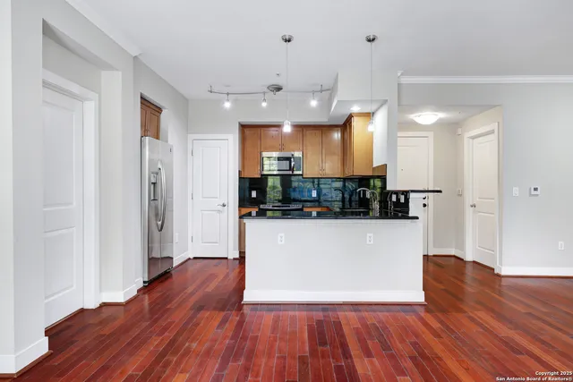 a view of a big room with wooden floor and windows