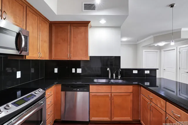 a kitchen with granite countertop stainless steel appliances a sink stove and microwave