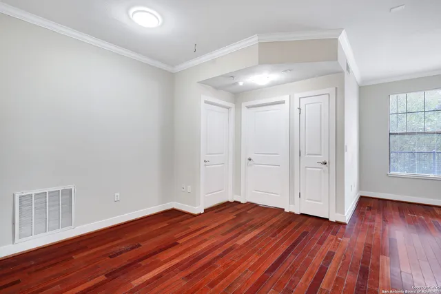 a view of empty room with wooden floor