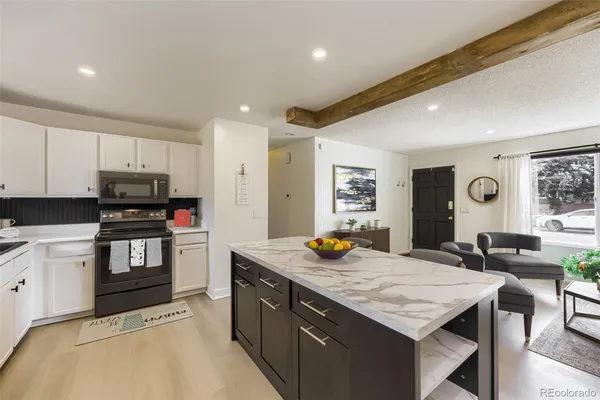 a kitchen with granite countertop a stove a sink dishwasher and a refrigerator with wooden floor