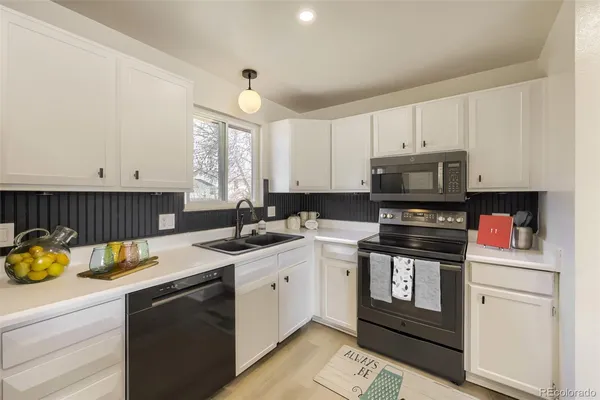 a kitchen with a sink a stove and cabinets