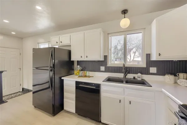 a kitchen with a refrigerator sink and cabinets