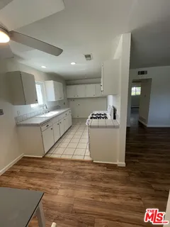 a large white kitchen with a stove a sink and a refrigerator