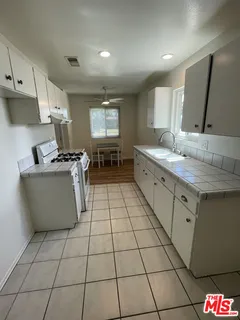 a kitchen with stainless steel appliances a stove a sink a counter top space and cabinets