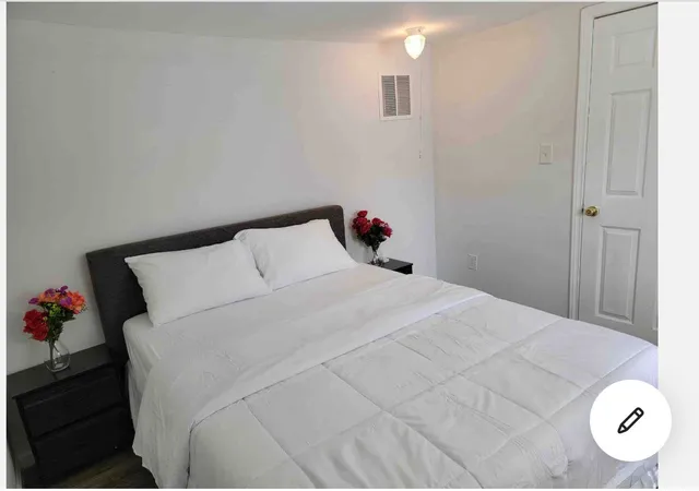 a bedroom with a bed and a potted plant