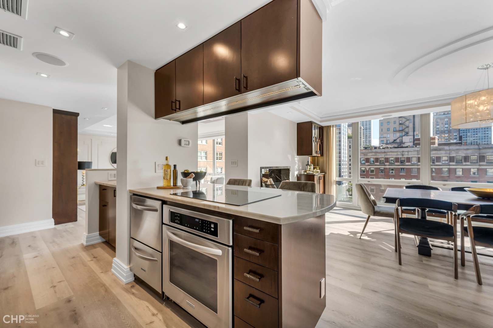 21 West Goethe Street, Unit 10G Chicago, IL 60610 - Photo 11 of 39 a kitchen with stainless steel appliances a stove a sink a dining table and chairs