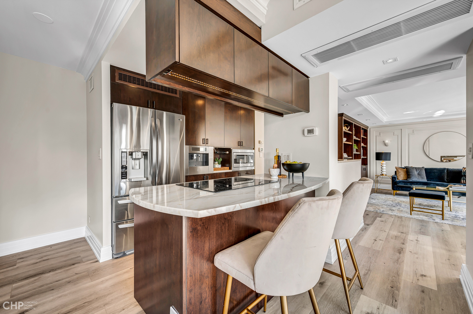 21 West Goethe Street, Unit 10G Chicago, IL 60610 - Photo 9 of 39 a kitchen with stainless steel appliances kitchen island granite countertop a table chairs in it and wooden floors