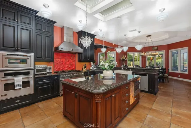 a kitchen area with granite countertop stainless steel appliances a sink a stove and a refrigerator