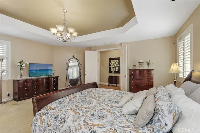 a bedroom with a bed and a chandelier
