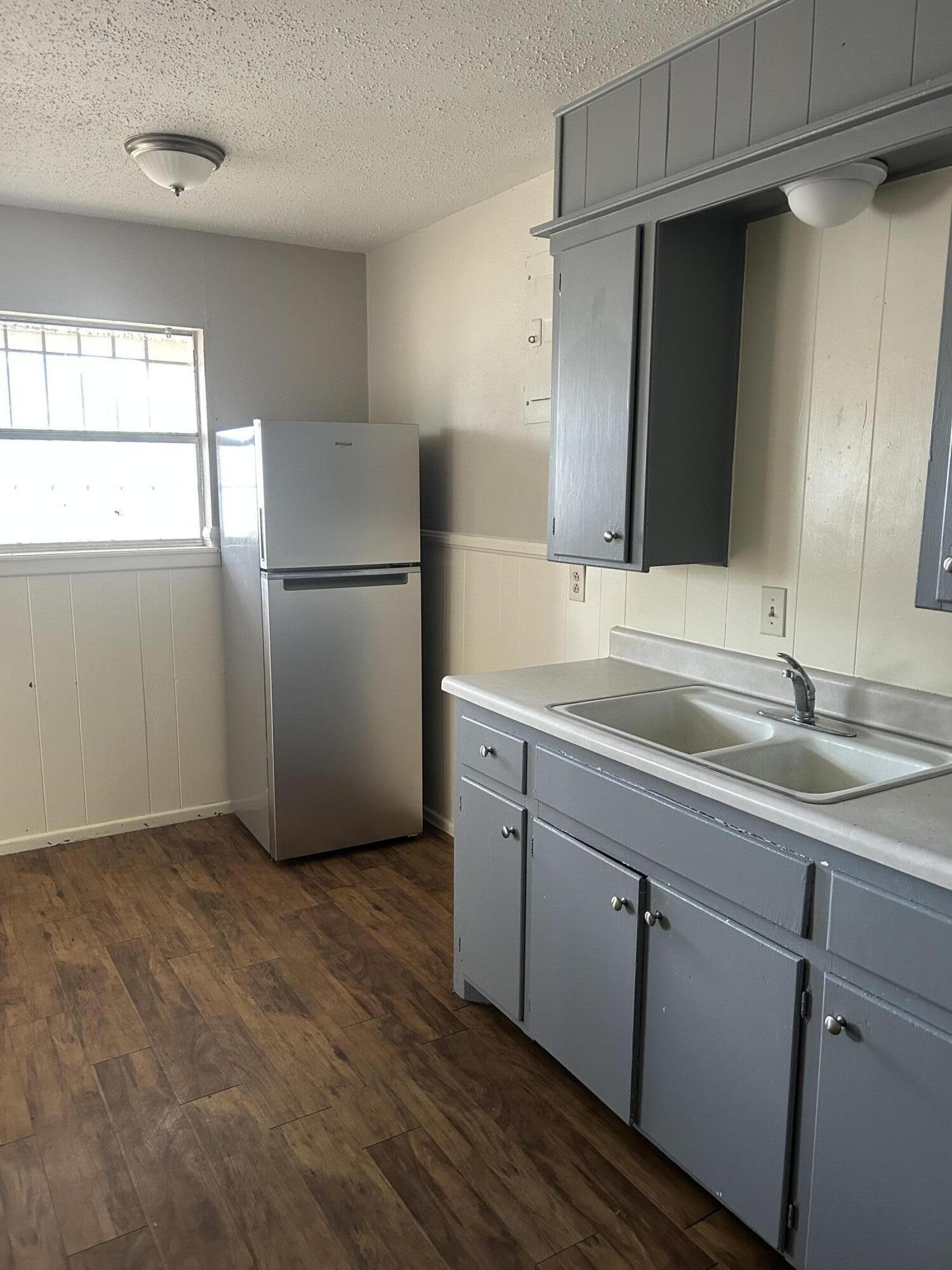 1102 42nd Street Lubbock, TX 79412 - Photo 8 of 16 a kitchen with a refrigerator sink and mirror