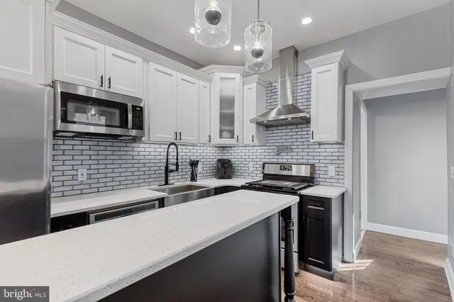 a kitchen with stainless steel appliances a stove sink microwave and cabinets