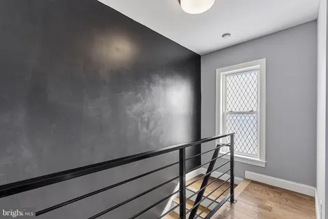 a view of a hallway with wooden floor and staircase