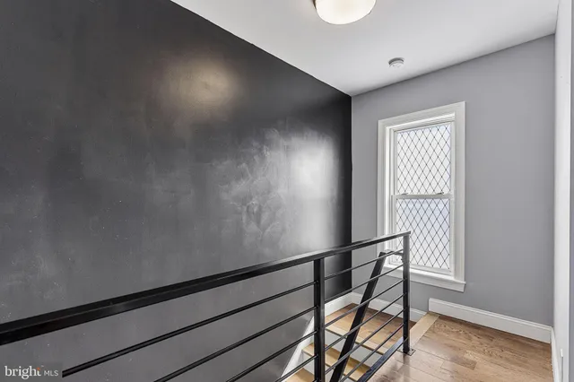 a view of a hallway with wooden floor and staircase