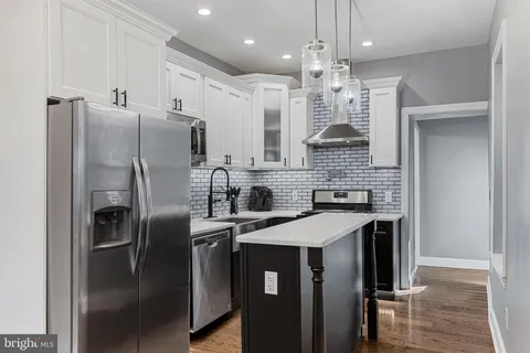 a kitchen with stainless steel appliances a sink a stove a microwave and cabinets