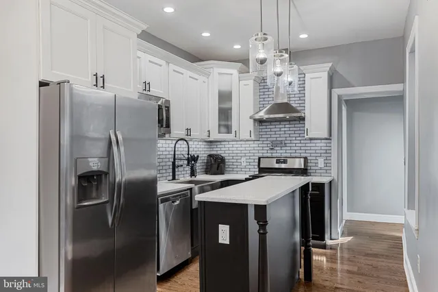 a kitchen with stainless steel appliances a sink a stove a microwave and cabinets