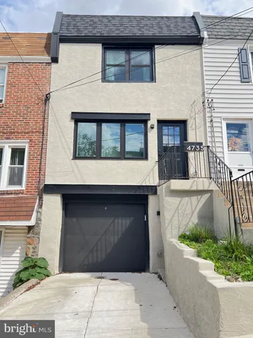 a front view of a house with potted plants