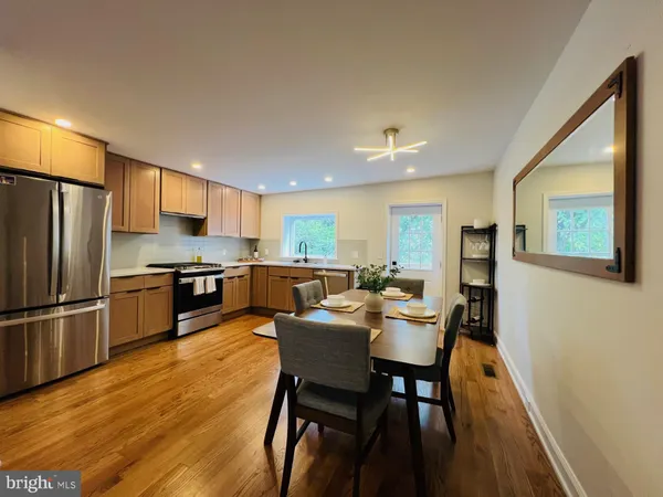 a view of a dining room with furniture a kitchen and wooden floor