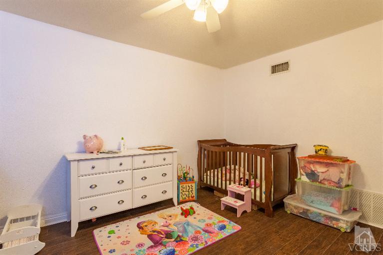 4724 Barnard Street Simi Valley, CA 93063 - Photo 11 of 30 a view of a bedroom with baby crib and furniture