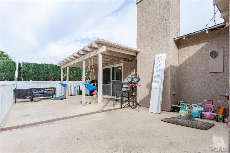 4724 Barnard Street Simi Valley, CA 93063 - Photo 23 of 30 a view of a patio with a dining table and chairs under an umbrella with a small yard