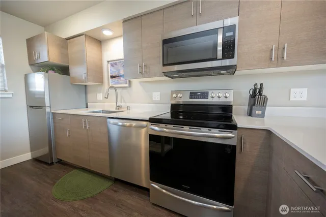 a kitchen with stainless steel appliances a stove a microwave and sink