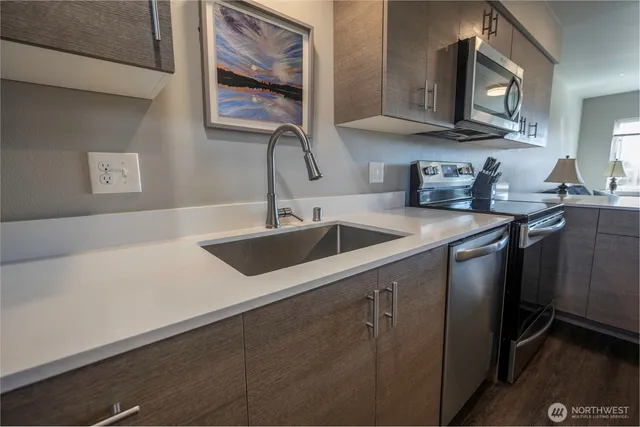 a kitchen with stainless steel appliances granite countertop a sink stove and cabinets