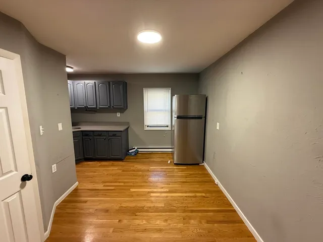 a view of kitchen with refrigerator and window