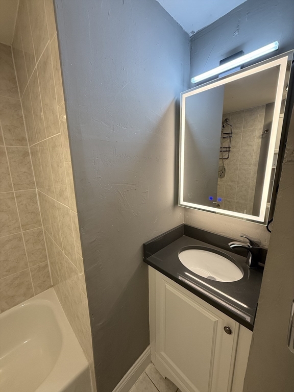 181 Bowen Street, Unit 1 Boston, MA 02127 - Photo 7 of 8 a bathroom with a sink a mirror and a bathtub