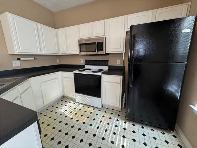 a kitchen with a sink a stove a microwave and cabinets