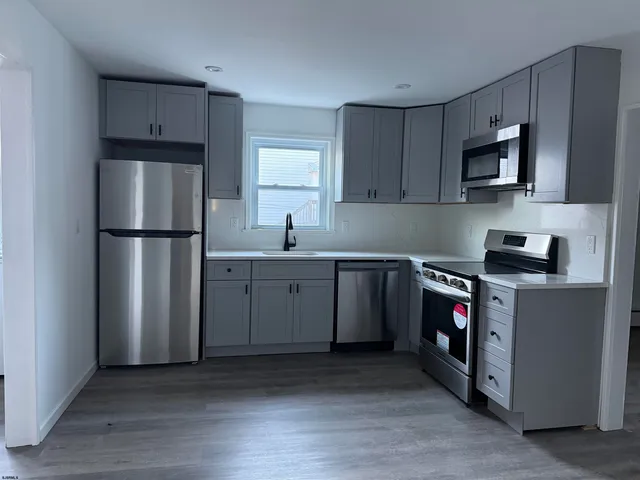 a kitchen with stainless steel appliances granite countertop a refrigerator sink and stove