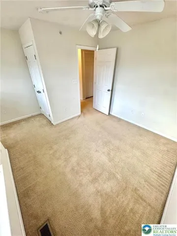 en empty room with chandelier fan and wooden floor