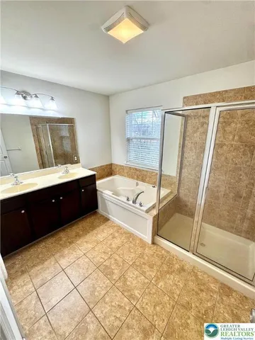 a spacious bathroom with a tub sink and mirror