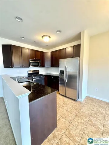 a kitchen with granite countertop a refrigerator and a sink