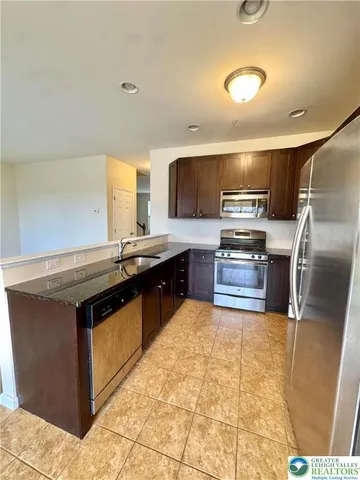 a kitchen with stainless steel appliances granite countertop a stove a sink and a refrigerator