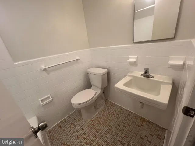 a bathroom with a sink a toilet and mirror