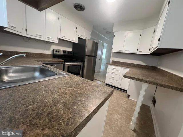 a kitchen with stainless steel appliances granite countertop a sink a stove and a refrigerator
